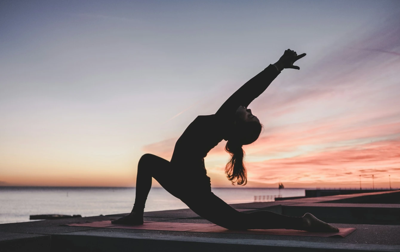 frau macht yoga vor sonnenuntergang